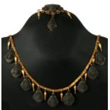 A 19th century Etruscan style yellow metal mounted lava cameo necklace and matching brooch.