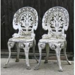 A pair of cast aluminium garden chairs.