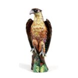 A continental porcelain figure depicting an eagle perched on a tree stump, 29cms (11.5ins) high.
