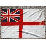 An early 20th century printed cotton British Navy white Ensign flag on its pole. The flag is