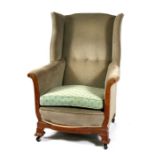 An Edwardian oak wing back armchair.