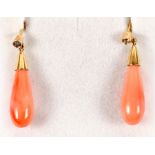 A pair of yellow metal coral drop earrings, each set with a single diamond.