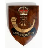 A King's African Rifles shield shaped mahogany plaque, 16cms (6.25ins) high.