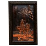 A Chinese copper plaque decorated in relief with figures on horseback and calligraphy, framed, 33 by