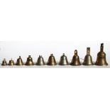 A collection of bronze bells, the largest 14cms (5.5ins) high together with a rose water