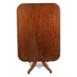 An early 19th century mahogany tilt-top table on turned column and quatrefoil base, 123cms (43.5ins)