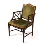 A faux bamboo carver chair with upholstered seat and back.