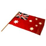 An early 20th century printed cotton Australian Red Ensign flag on its pole. The flag is 69cms (