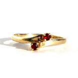 A 9ct gold garnet crossover ring, approx UK size 'Q'.