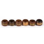 A set of six napkin rings made from the teak of various ships to include HMS Ganges, HMS Valiant and