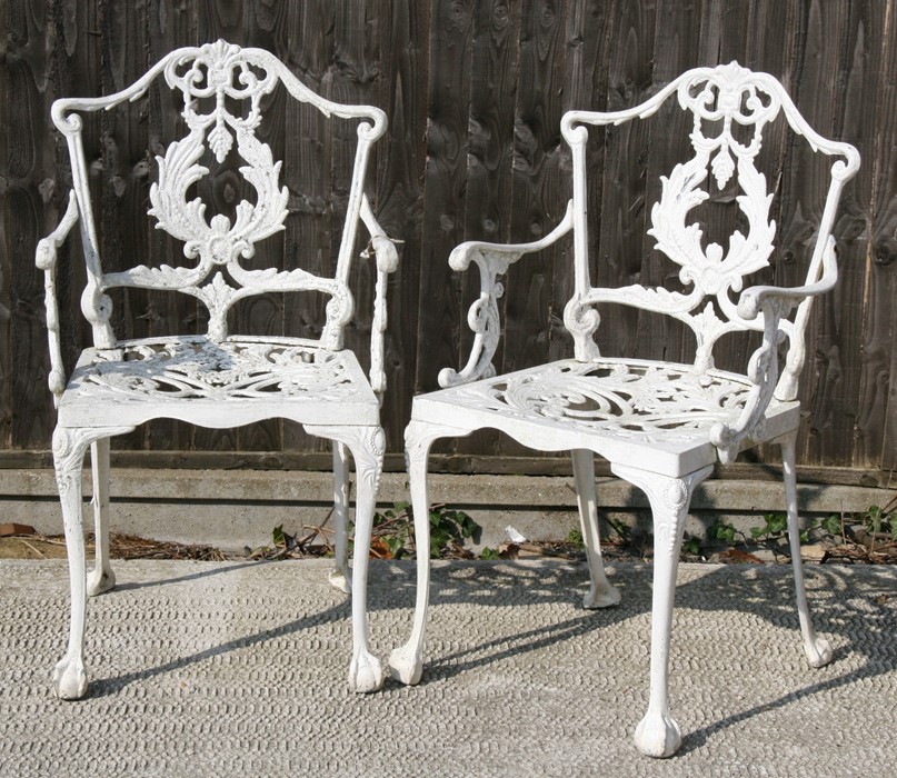 A pair of cast aluminium garden armed chairs.