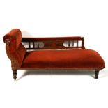 A late 19th century oak and upholstered chaise longue on turned legs, 165cm (65 ins) long.