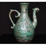 A Chinese green crackle glazed wine pot or ewer decorated with fruit and a phoenix spout, 19cms (7.