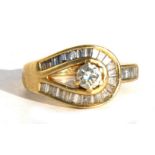 An 18ct gold diamond ring with central diamond surrounded by baguette cut diamonds, approx UK