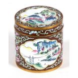 A Chinese enamel box & cover of cylindrical form decorated with a landscape and foliate scrolls on a