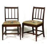 A pair of Georgian mahogany side chairs with drop-in needlework seats, on square tapering legs (2).