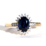 A 9ct gold diamond and sapphire dress ring, the central sapphire surrounded by diamonds, with