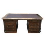 A late 19th / early 20th century oak pedestal partners desk with four frieze drawers and pedestals