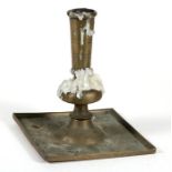 An early brass candlestick on a square form base, 16cms (6.25ins) high.