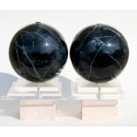 A pair of modern design marbleised spheres on acrylic stands, 38cms (15ins) high.