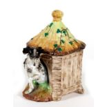 A Victorian tobacco box in the form of a dog in his kennel, 19.5cms (7.75ins) high.Condition