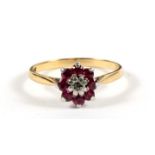 An 18ct gold and platinum ruby and diamond cluster ring, approx UK size 'N'.