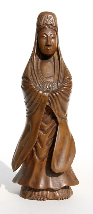 A Chinese carved wooden figure depicting Guanyin, 20cms (8ins) high.