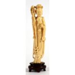 A late 19th / early 20th century Chinese figure depicting a robed maiden holding a staff and a