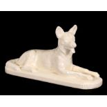 An Art Deco white glazed pottery figure of a recumbent Alsatian, indistinct impressed mark to