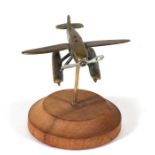 A trench art style brass model of a Schneider Trophy seaplane with spinning propeller mounted on a
