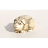 A signed Japanese ivory netsuke in the form of a puppy, 4.5cms (1.25ins) long.