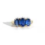 A 9ct gold dress ring set with three large blue stones, approx UK size 'S'.