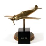 A WW2 brass model of the German Messerschmitt ME 109 with spinning propeller standing on its brass