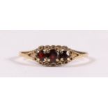 A 9ct gold dress ring set with three garnets, approx UK size 'N'.
