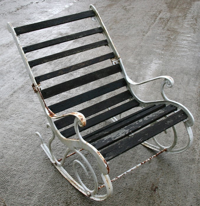 A cast iron & wooden slatted garden rocking chair.