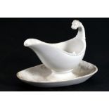 A 19th century white glazed gravy boat on stand with lion mask handle.Condition Report Good