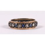 A yellow metal eternity ring set with blue & white stones, approx UK size 'M'.