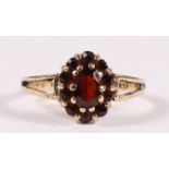 A 9ct gold garnet cluster dress ring, approx UK size 'K'.