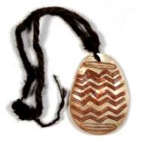 An Australian Aboriginal shell pendant with 'zig zag' design. 17cm (6.5 ins) high