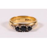 An 18ct gold three stone sapphire ring, approx UK size 'K'.