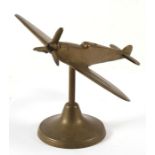A large brass model of the WW2 Supermarine Spitfire with spinning propeller standing on its brass