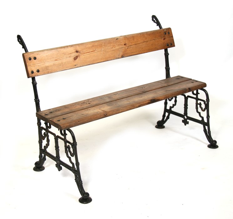 A Victorian cast iron garden bench with pine board seat and back, 120cms (47.25ins) wide.