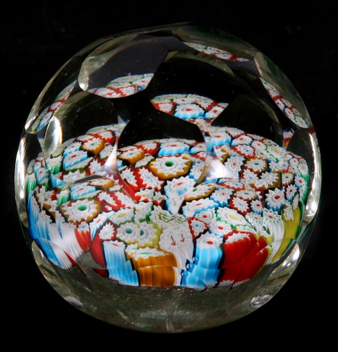 A faceted millefiori glass paperweight with ground out pontil mark, 8cms (3.25ins) diameter.