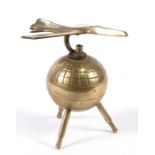 A 1950s brass desk ornament of a jet aircraft over a globe standing on tripod legs. The jet is 13cms