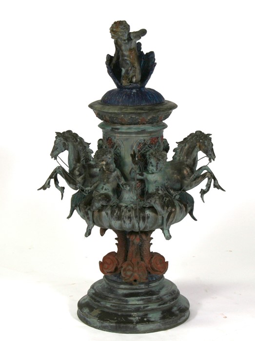 A bronzed centre piece decorated with hippocampus and cherubs, surmounted with a further cherub