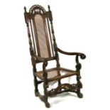 A 17th century walnut high back elbow chair with a caned panel back and seat, on carved and turned