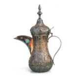A Turkish/Islamic white metal (?) dallah coffee pot with embossed foliate decoration. 29cm (11.5