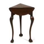 An oak drop leaf occasional table, the circular top twisting to support three leaves, standing on