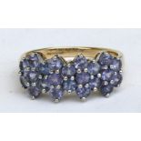 A 9ct gold dress ring set with twenty two pale purple stones. Approx UK size R