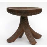 African/tribal art. A Nigerian carved Igbo stool, the dished top on four out-swept legs. 34cm (13.